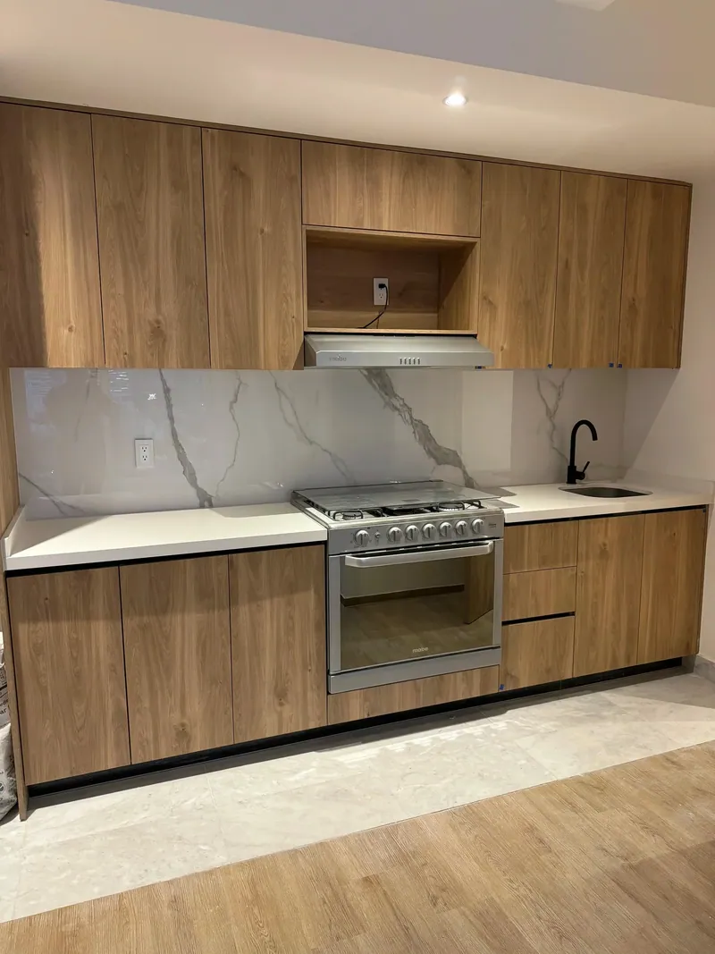 Cocina con frentes de madera y cubierta de mármol. Suministro e instalación de Luis Llano.